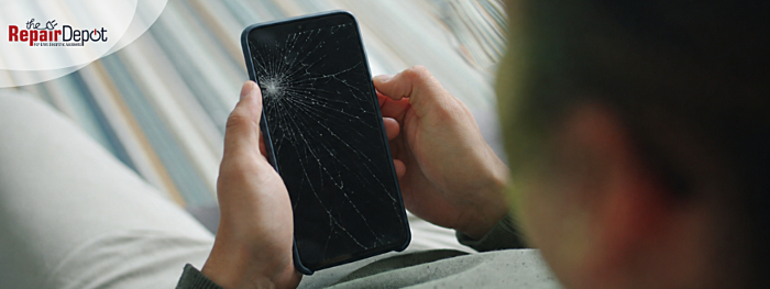 Person holding phone with a cracked screen