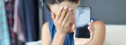 Sad girl holding a phone with a broken screen