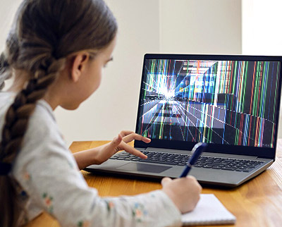 Young girl using Chromebook with glitching screen