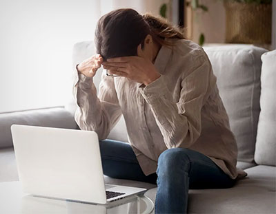 Woman stressed in front of laptop that shut down