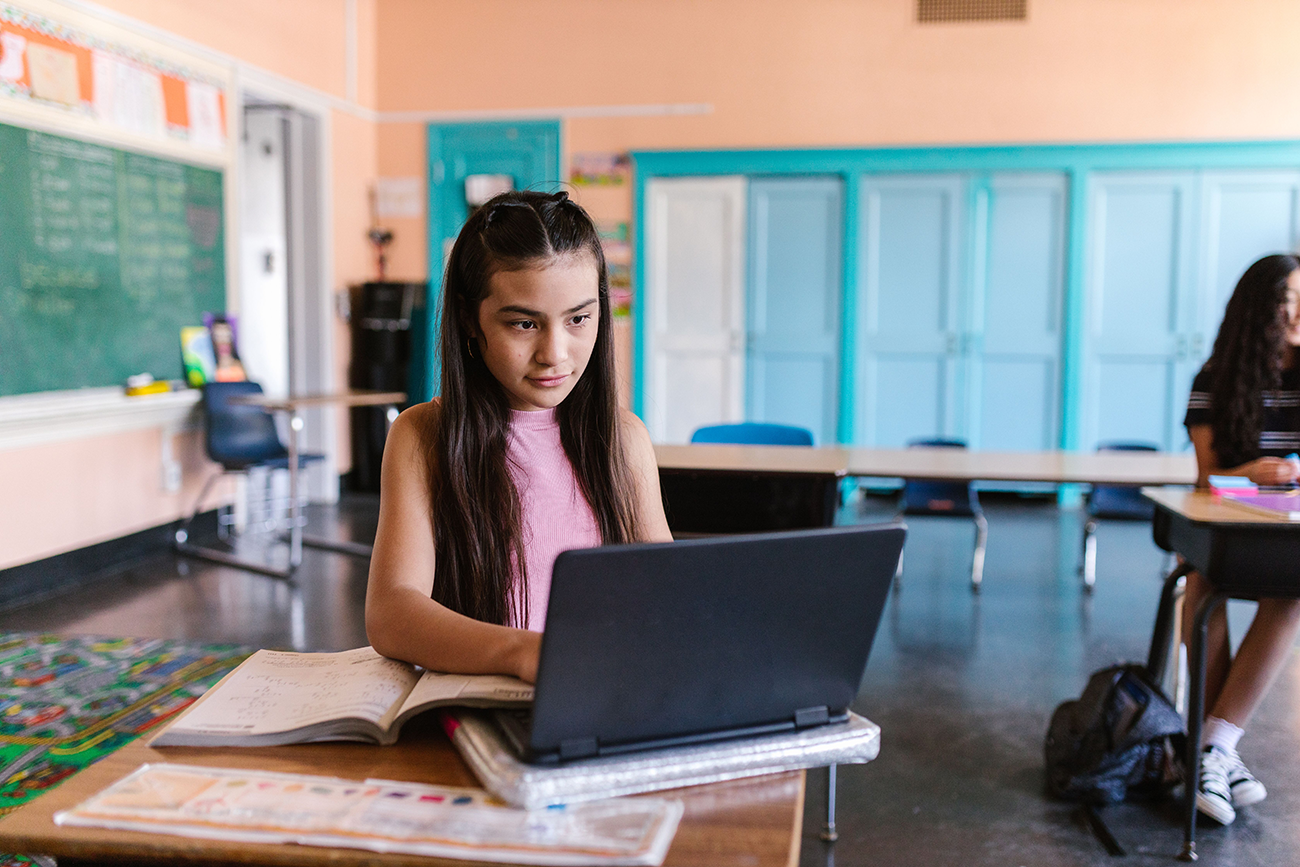 Student using a Chromebook in a school classroom