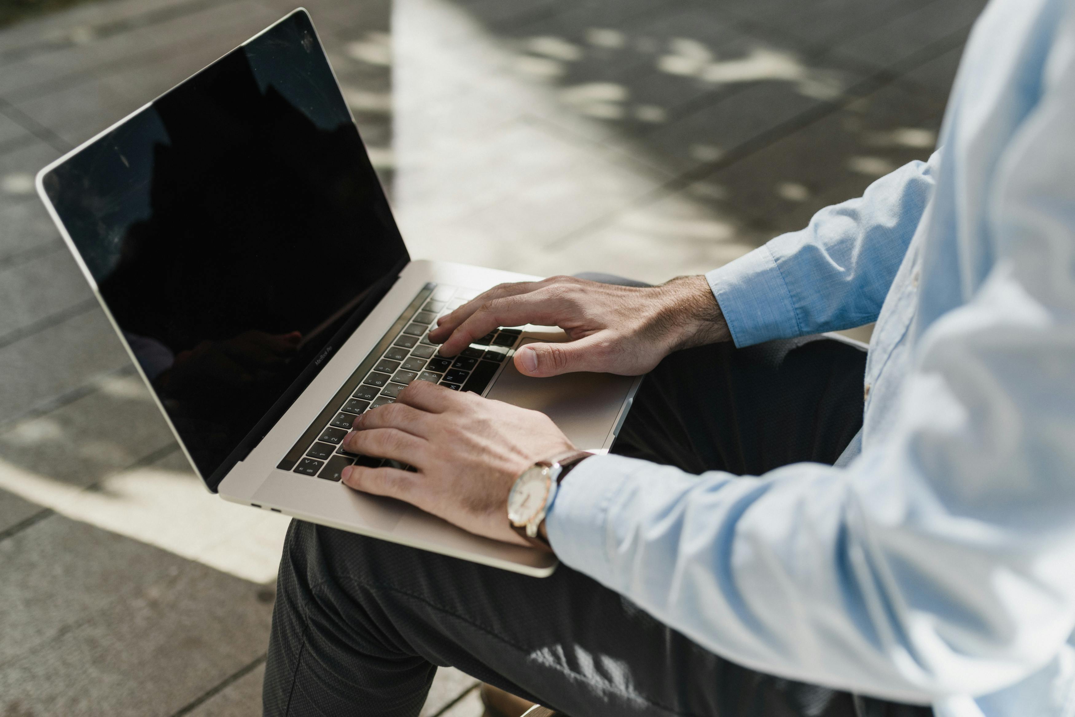 Person working on Macbook outside